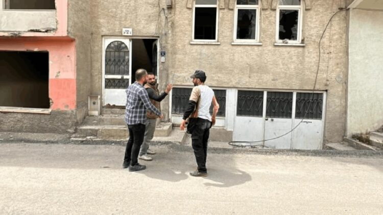 Depremde ağır hasar alan binaya girip pencereden düştü